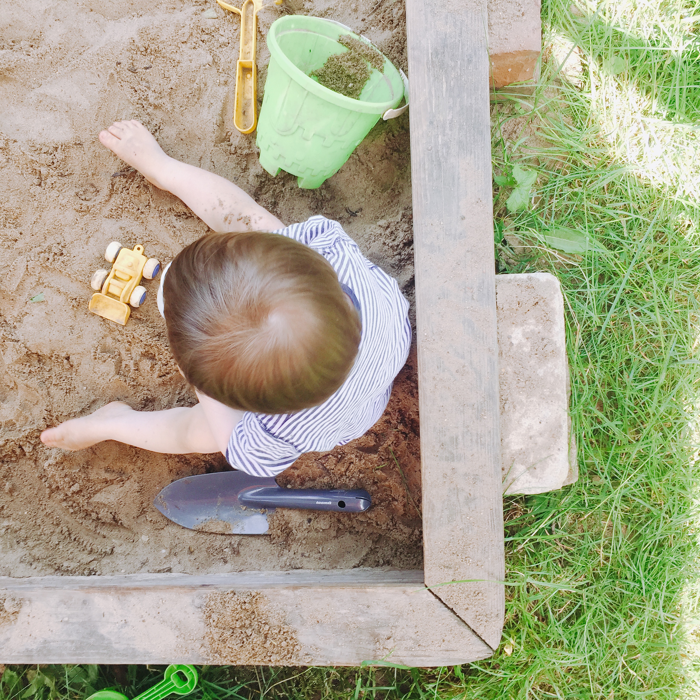 Kind spielt im Sand